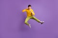 Full size photo of young crazy positive funky funny man doing karate in air jumping on purple color background