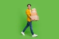 Full size photo of young handsome good mood man go walk hold carton boxes move new house isolated on green color Royalty Free Stock Photo