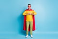 Full size photo of young handsome serious powerful super man in red cape and mask isolated on blue color background