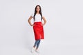 Full size photo of young happy cheerful smiling woman hairdresser in red apron isolated on grey color background Royalty Free Stock Photo