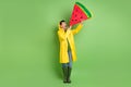 Full size photo of young happy excited crazy positive man in raincoat hold hug watermelon isolated on green color