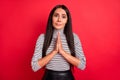 Full size photo of young unhappy upset scared girl asking begging hold hands in prayer isolated on red color background Royalty Free Stock Photo