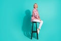 Full size photo of young woman sit chair turn around look empty space dressed stylish pink clothes isolated on