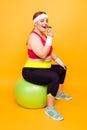 Full-size portrait of cunning layabout cheerful excited glad lazy addicted to sweets plump woman dressed in sportive outwear Royalty Free Stock Photo