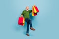 Full size portrait of delighted overjoyed funny granddad raise hold packages celebrate isolated on blue color background