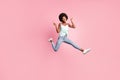 Full size portrait of excited person jump show v-sign wear jeans singlet sneakers on pink color background