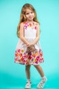 Beautiful little girl with long blond hair standing on a blue background Royalty Free Stock Photo