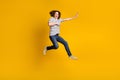 Full size portrait of nice young man jump fight empty space wear striped t-shirt isolated on yellow color background Royalty Free Stock Photo