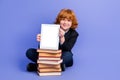 Full size portrait of small boy sit floor pile stack book showing empty space tablet display isolated on purple color Royalty Free Stock Photo