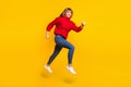 Full size profile photo of blond optimistic lady jump wear red sweater jeans sneakers isolated on bright yellow color Royalty Free Stock Photo