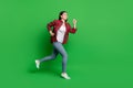 Full size profile photo of brunette funny young lady run wear shirt jeans isolated on green color background