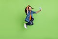 Full size profile photo of cool small girl jump do selfie wear hoop jeans shoes isolated on green background