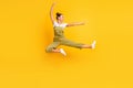 Full size profile photo of optimistic brunette lady jump fight wear bright t-shirt overall sneakers isolated on yellow Royalty Free Stock Photo