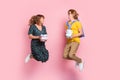 Full size profile photo of optimistic funny couple jump hold present wear colorful clothes isolated on pastel pink Royalty Free Stock Photo