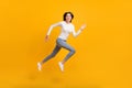 Full size profile photo of optimistic girl jump run wear sweater jeans sneakers isolated on yellow color background Royalty Free Stock Photo