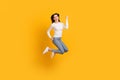 Full size profile photo of optimistic girl jump wear sweater jeans sneakers isolated on yellow color background Royalty Free Stock Photo