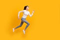 Full size profile photo of optimistic nice girl jump run wear sweater jeans sneakers isolated on yellow color background Royalty Free Stock Photo