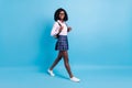 Full size profile side photo of black schoolgirl happy smile go walk step lesson isolated over blue color background