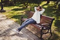 Full size profile side photo of charming relaxed afro american man sit bench rest hands above head outside in park Royalty Free Stock Photo