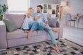 Full size profile side photo of cheerful young couple sitting couch apartment enjoy weekend romantic indoors Royalty Free Stock Photo