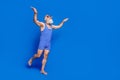 Full size profile side photo of funky funny old man in goggles diving in swimming pool isolated on blue color background