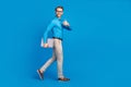 Full size profile side photo of young man happy smile go walk show thumb-up advert advise laptop isolated over blue Royalty Free Stock Photo