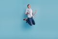 Full size profile side photo of young man rejoice victory jump fists hands isolated over blue color background