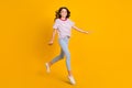 Full size profile side photo of young schoolgirl happy positive smile go walk step jump isolated over yellow color