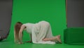 Full-size side view green screen chroma key shot of a posessed female, woman figure, ghost, poltergeist, zombie crawling