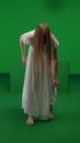 Full-size vertical green screen, chroma key shot of a posessed female, woman figure, ghost, poltergeist, zombie moving