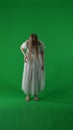 Full-size vertical green screen, chroma key shot of a posessed female, woman figure, ghost, poltergeist, zombie moving