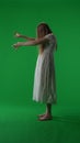 Full-size vertical side view green screen, chroma key shot of a posessed female figure, ghost, poltergeist, zombie