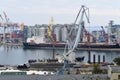 Full-slewing switch crane of gray color against the background of the cargo berth.