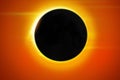 Full Solar eclipse background with glowing sun, orange sky and dark moon in front Royalty Free Stock Photo