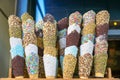 Full stacks of special colorful homemade cone decoration for ice cream with varieties of glazing including sprinkles, almond