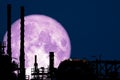 Full Strawberry Moon back on silhouette refinery on night sky Royalty Free Stock Photo