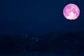 full strawberry moon on night sky back over silhouette mountain Royalty Free Stock Photo