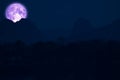 full strawberry moon on night sky back over silhouette mountain Royalty Free Stock Photo