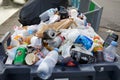 Full trash bin with colorful rubbish in Paris