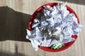 Full trash bin with crumpled paper scattered around Royalty Free Stock Photo