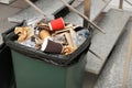 Full trash bin near stair way indoors. Royalty Free Stock Photo