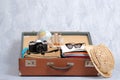 Full travel suitcase on grey background, opened case with travel clothing and accessories. Royalty Free Stock Photo