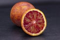 Full and two half of blood red oranges isolated on black shale background Royalty Free Stock Photo