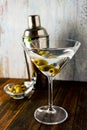 A full vertical shot of a martini glass with olives on a light background Royalty Free Stock Photo