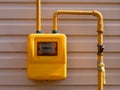 A full view of residential urban natural gas meter measuring gas consumption, outside house gas meter in yellow box Royalty Free Stock Photo