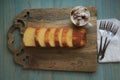 Full viewWooden cutting board pound cake sliced and coffee.