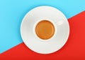 Full white espresso coffee cup on red and blue