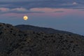 Full Wolf Moon Rising Over Desert Mountains