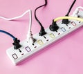 Fulled electrics power supply plug on pink background