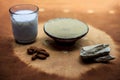 Fuller`s earth face mask in a clay bowl on brown fabric`s surface along with some milk and almonds. For softer skin Royalty Free Stock Photo